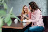 two women dining on brown wooden table