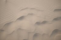 a sand dune with some small waves in the middle