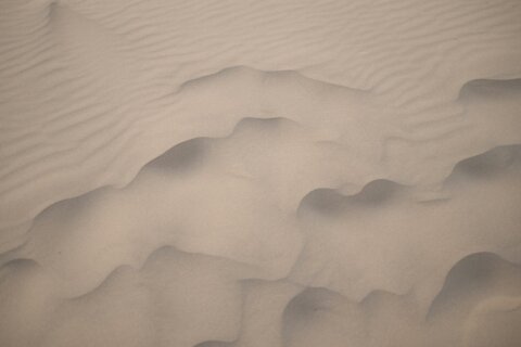a sand dune with some small waves in the middle